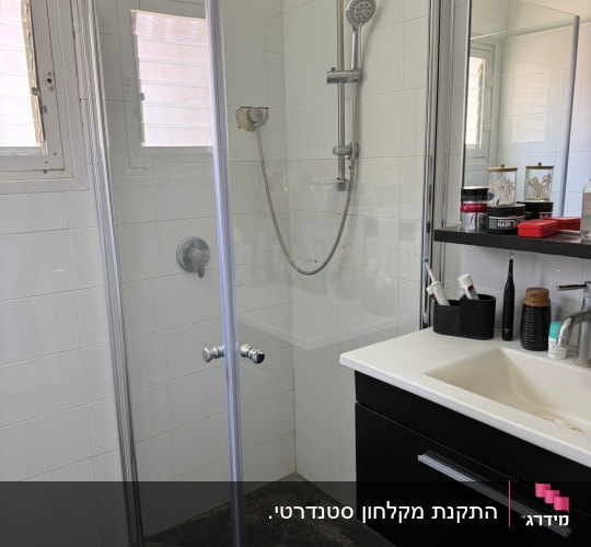 מקלחון זכוכית עם ראש מקלחת וכיור בחדר אמבטיה